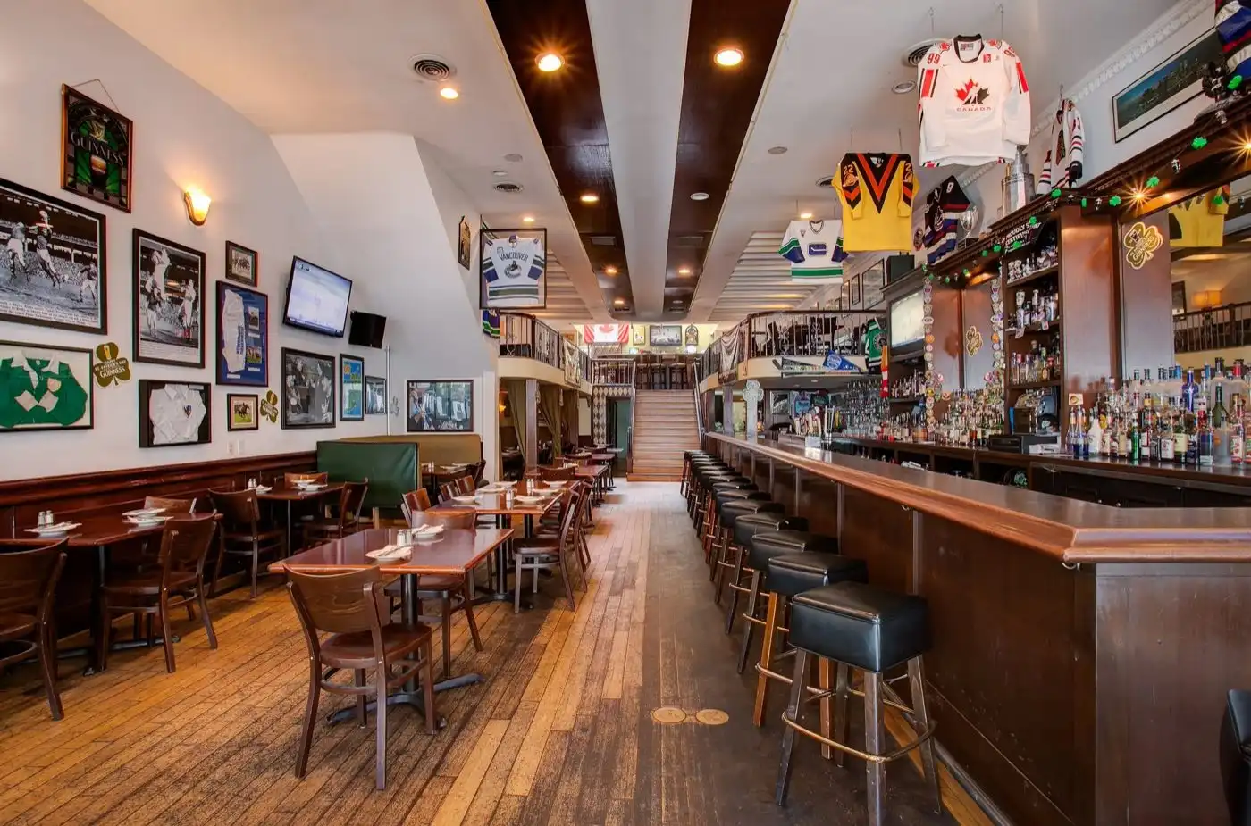 Inside Stout Public House — the bi-level bar lined with hockey jerseys